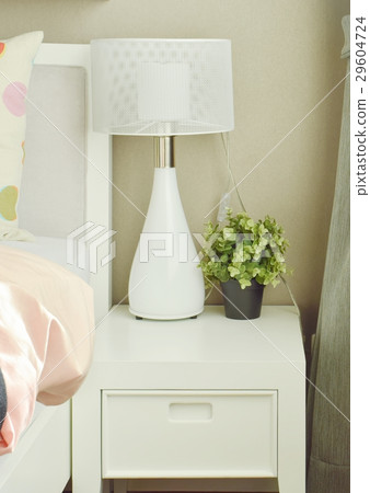 White lamp and flower pot on bedside table White lamp and flower pot on bedside table 29604724