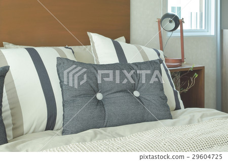 Gray and brown strip pillows setting on bed Gray and brown strip pillows setting on bed 29604725