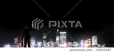 Businessman viewing night glowing city Businessman viewing night glowing city 29605897