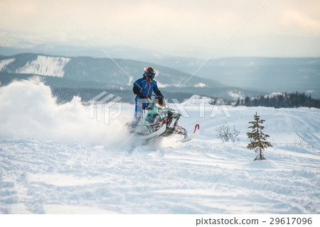 Rider on the snowmobile in the mountains Rider on the snowmobile in the mountains 29617096