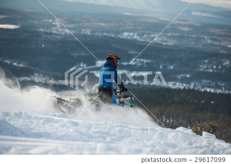 Rider on the snowmobile in the mountains Rider on the snowmobile in the mountains 29617099