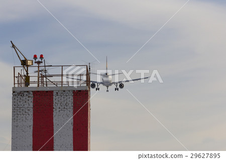 Airplane landing to the airport over the building Airplane landing to the airport over the building 29627895