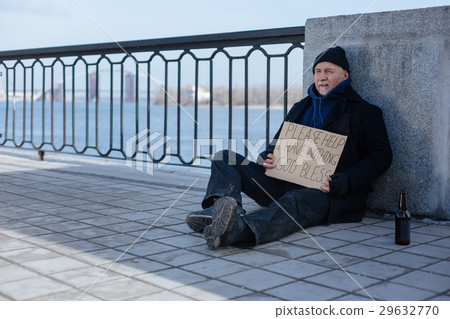 Poor man sitting near glass bottle Poor man sitting near glass bottle 29632770
