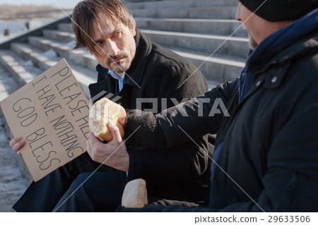 Angry disheveled young man taking bread Angry disheveled young man taking bread 29633506