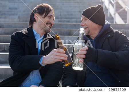 Positive delighted friends touching their bottles Positive delighted friends touching their bottles 29633509
