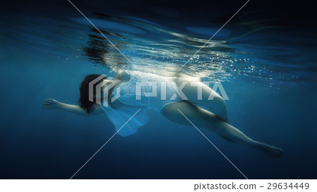 The girl in a white bathing suit under water The girl in a white bathing suit under water 29634449