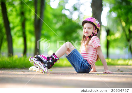 Pretty little girl learning to roller skate outdoors Pretty little girl learning to roller skate outdoors 29634767