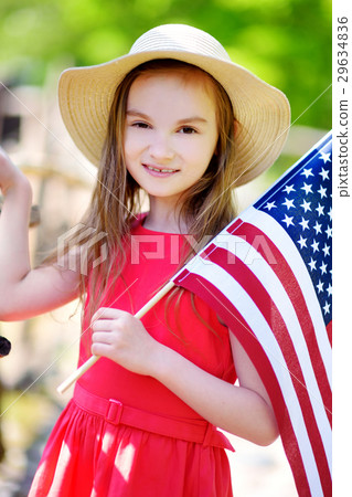 Adorable little girl holding american flag outdoors on beautiful summer day 29634836