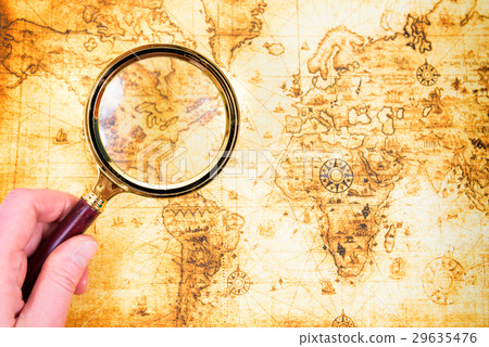 Old map and magnifying glass in a hand Old map and magnifying glass in a hand 29635476