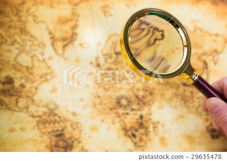 Old map and magnifying glass in a hand 29635478