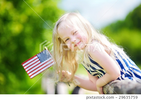 Adorable little girl holding american flag outdoors on beautiful summer day 29635759