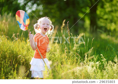 Cute little girl catching butterflies and bugs with her scoop-net 29635803