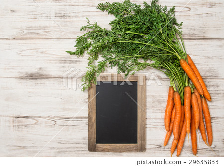 Fresh carrots roots with green leaves blackboard 29635833