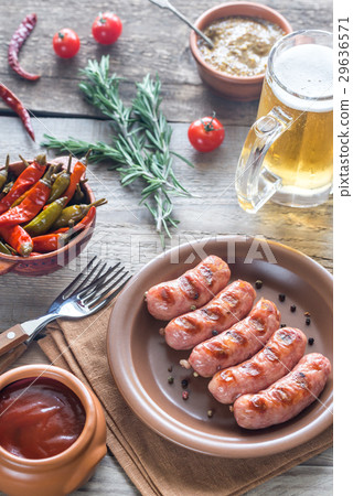 Grilled sausages with appetizers and mug of beer 29636571