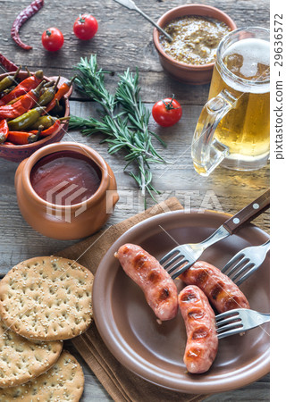 Grilled sausages with appetizers and mug of beer 29636572