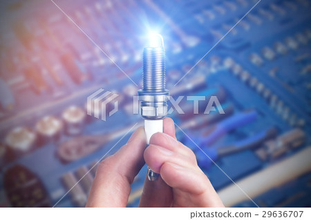 Mechanic holds a spare part spark plug in hand Mechanic holds a spare part spark plug in hand 29636707