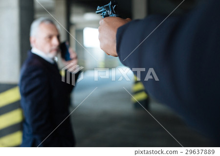 Selective focus of a handgun directed at the Selective focus of a handgun directed at the 29637889