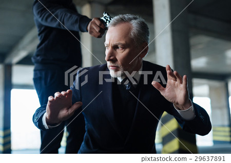 Frightened rich businessman doing commands of a Frightened rich businessman doing commands of a 29637891