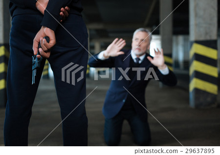 Selective focus of a handgun being held behind the Selective focus of a handgun being held behind the 29637895