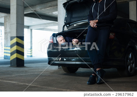 Calm relaxed man leading on the car boot 29637962