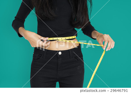 Young woman measuring her waist with tape Young woman measuring her waist with tape 29646791