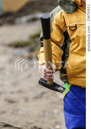 detail of child in overalls with hammer in action  29650911