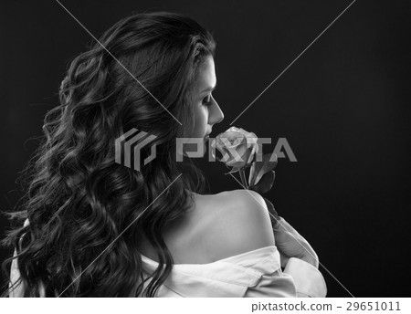 Beautiful brunette woman sniffing rose Beautiful brunette woman sniffing rose 29651011