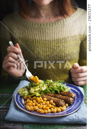 Woman eat cevapcici on the wooden table vertical Woman eat cevapcici on the wooden table vertical 29655277