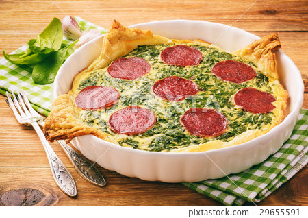 Tart with spinach and slices of salami. 29655591