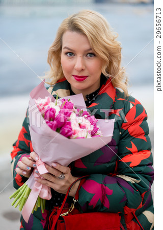 Young blonde woman with flowers bouquet on a city Young blonde woman with flowers bouquet on a city 29656713