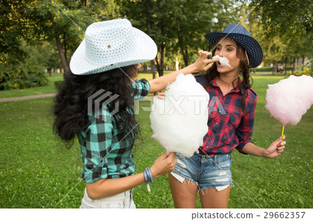 beautiful girls in cowboy hats eating cotton candy beautiful girls in cowboy hats eating cotton candy 29662357