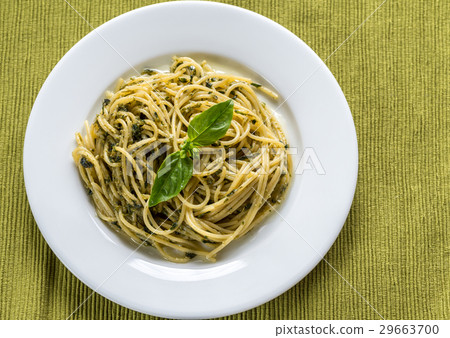 Portion of pasta with pesto sauce and basil leaf Portion of pasta with pesto sauce and basil leaf 29663700