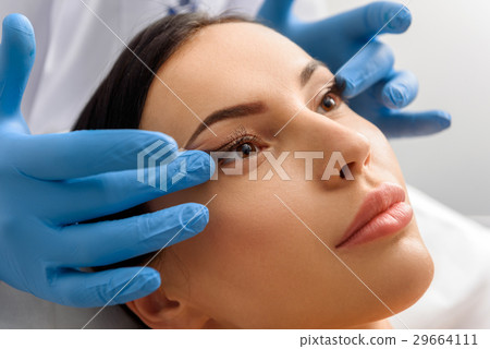 Unconcerned female taking face massage in Unconcerned female taking face massage in 29664111