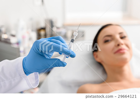 Physician arm holding injector in cosmetology Physician arm holding injector in cosmetology 29664121