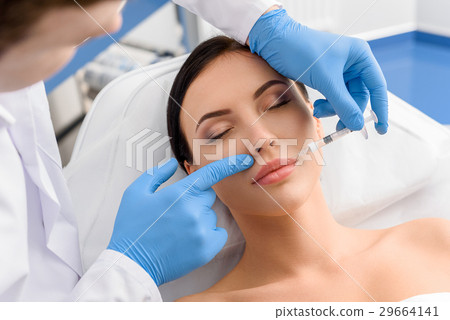 Satisfied woman receiving injection in face Satisfied woman receiving injection in face 29664141