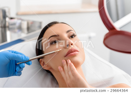 Calm girl watching at reflexion in surgery room 29664364