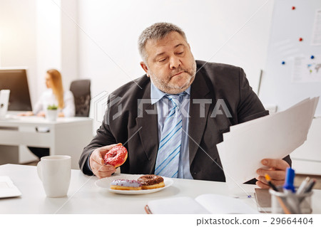 Busy engaged employee eating at his workplace 29664404
