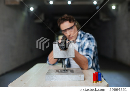 Serious confident marksman aiming with a rifle 29664861