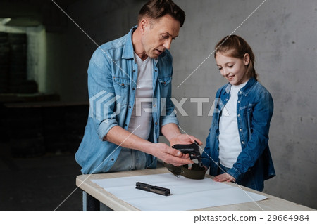 Pleasant nice man looking at the disassembled gun 29664984