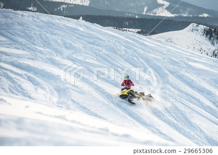 Rider on the snowmobile in the mountains . the 29665306