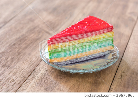 Delicious rainbow cake on plate on wooden table 29673963