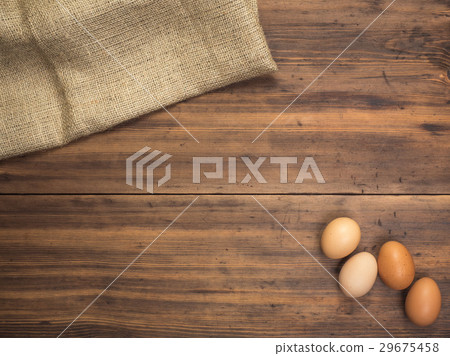 Brown chicken eggs lay on a piece of burlap on a Brown chicken eggs lay on a piece of burlap on a 29675458