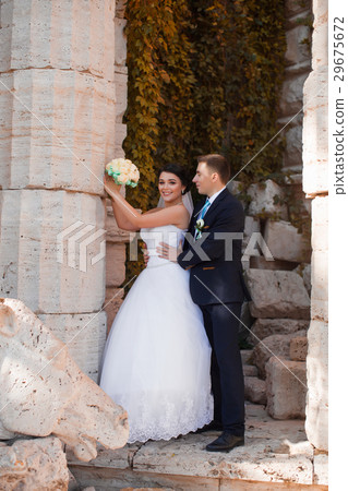 Happy newlyweds are standing by the column Happy newlyweds are standing by the column 29675672