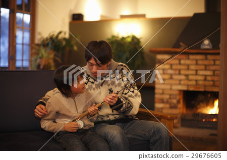 A father looking at a fishing rod 29676605