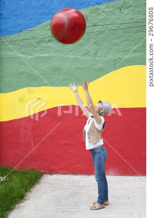 A young woman throwing a big ball 29676808
