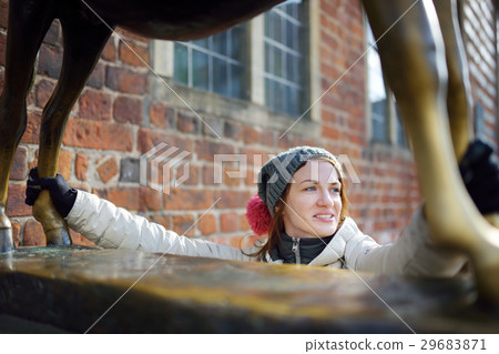 Young tourist touching famous statue in the center of Bremen known as Bremen Town Musicians Young tourist touching famous statue in the center of Bremen known as Bremen Town Musicians 29683871