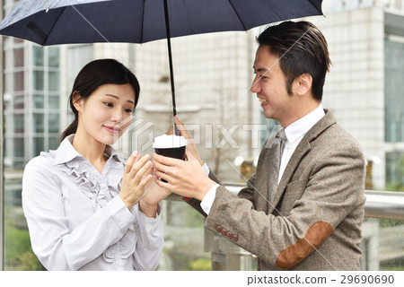 Couple holding umbrella in the rain 29690690