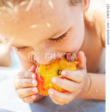 Boy eating a peach Boy eating a peach 29691407
