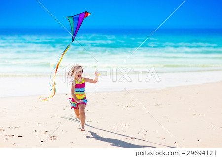 Child flying kite on tropical beach 29694121