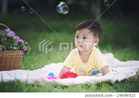 Asia Baby boy sitt on green grass with soap bubble 29696925
